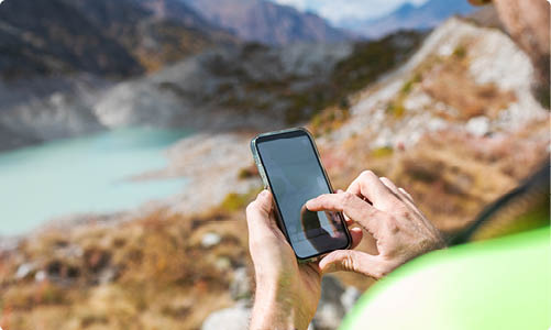 A man is standing on top of a windmill, wearing a yellow jacket and a helmet. AI generated content